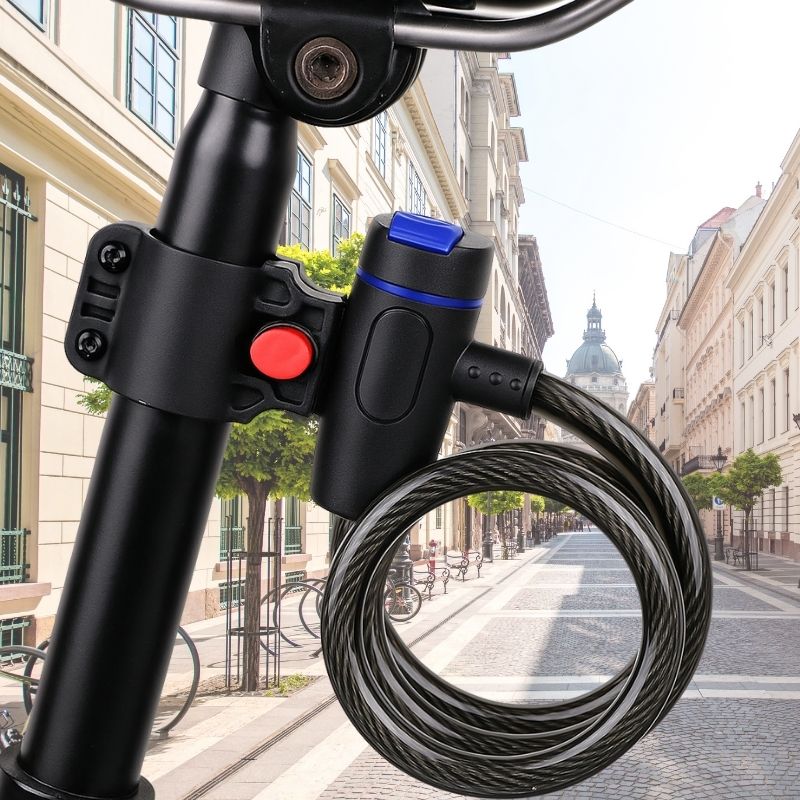 Coiled bike lock attached to a bike seatpost with urban buildings in background