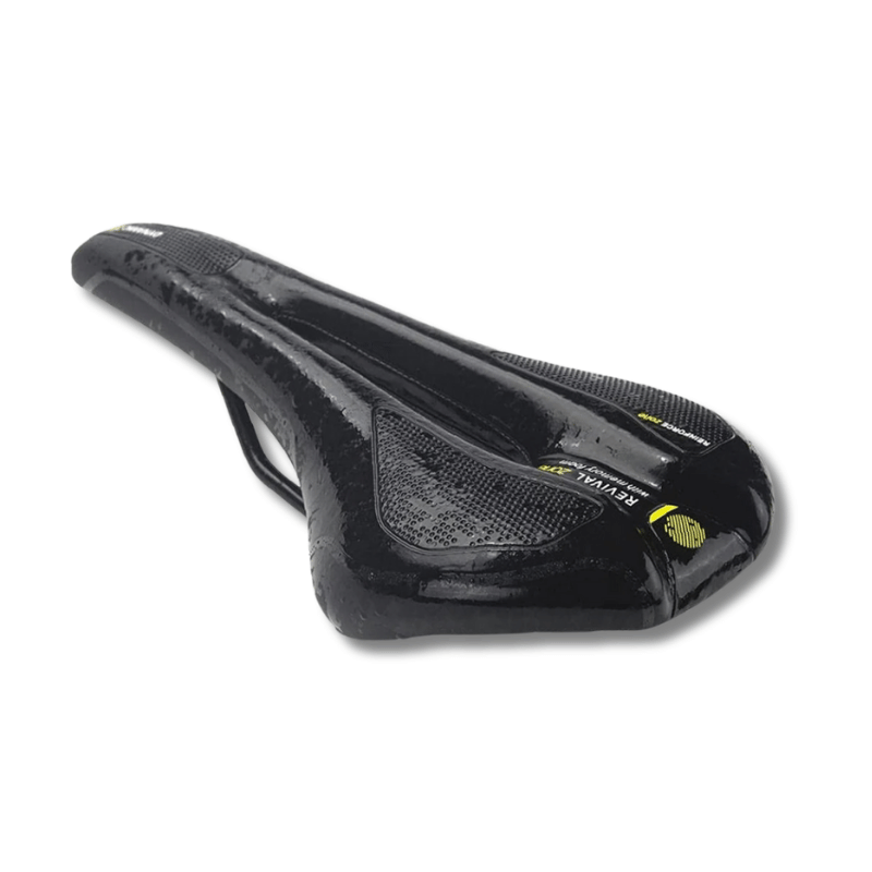 Bike seat on pavement with black background and water