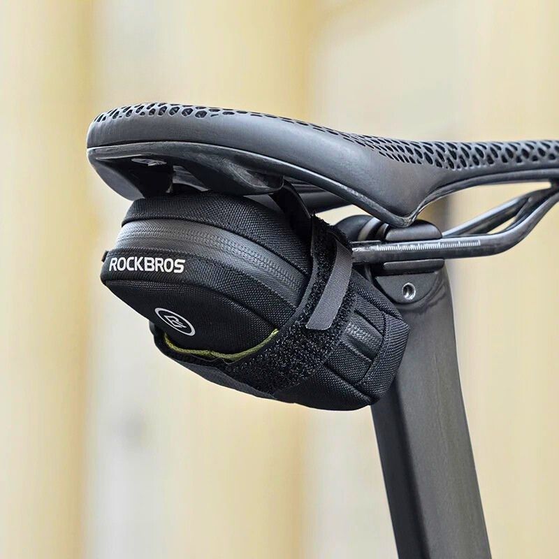 Compact saddle bag mounted under a green city bike saddle