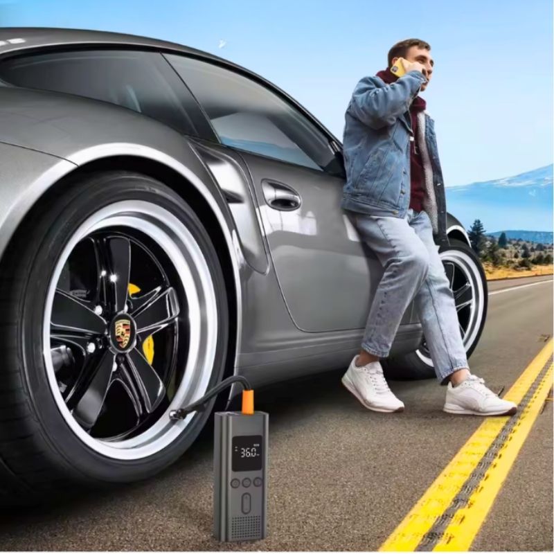 Man inflating car tyre with portable cordless air pump