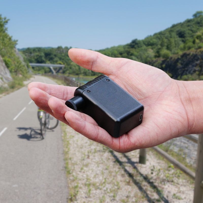 Lightweight pocket-size electric pump held in hand outdoors