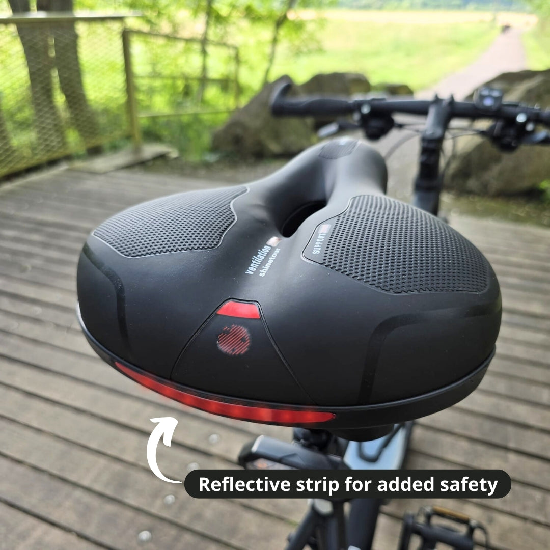 Wide bike seat with reflective safety strip installed on a bicycle.