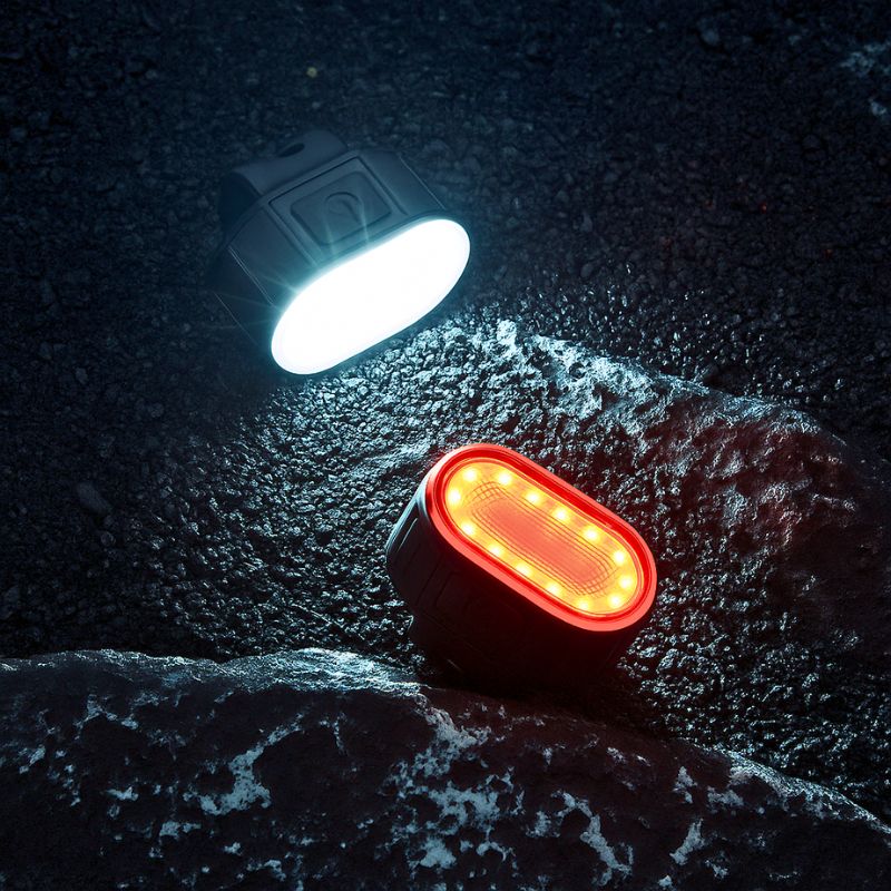White and red LED lights shining on wet asphalt at night